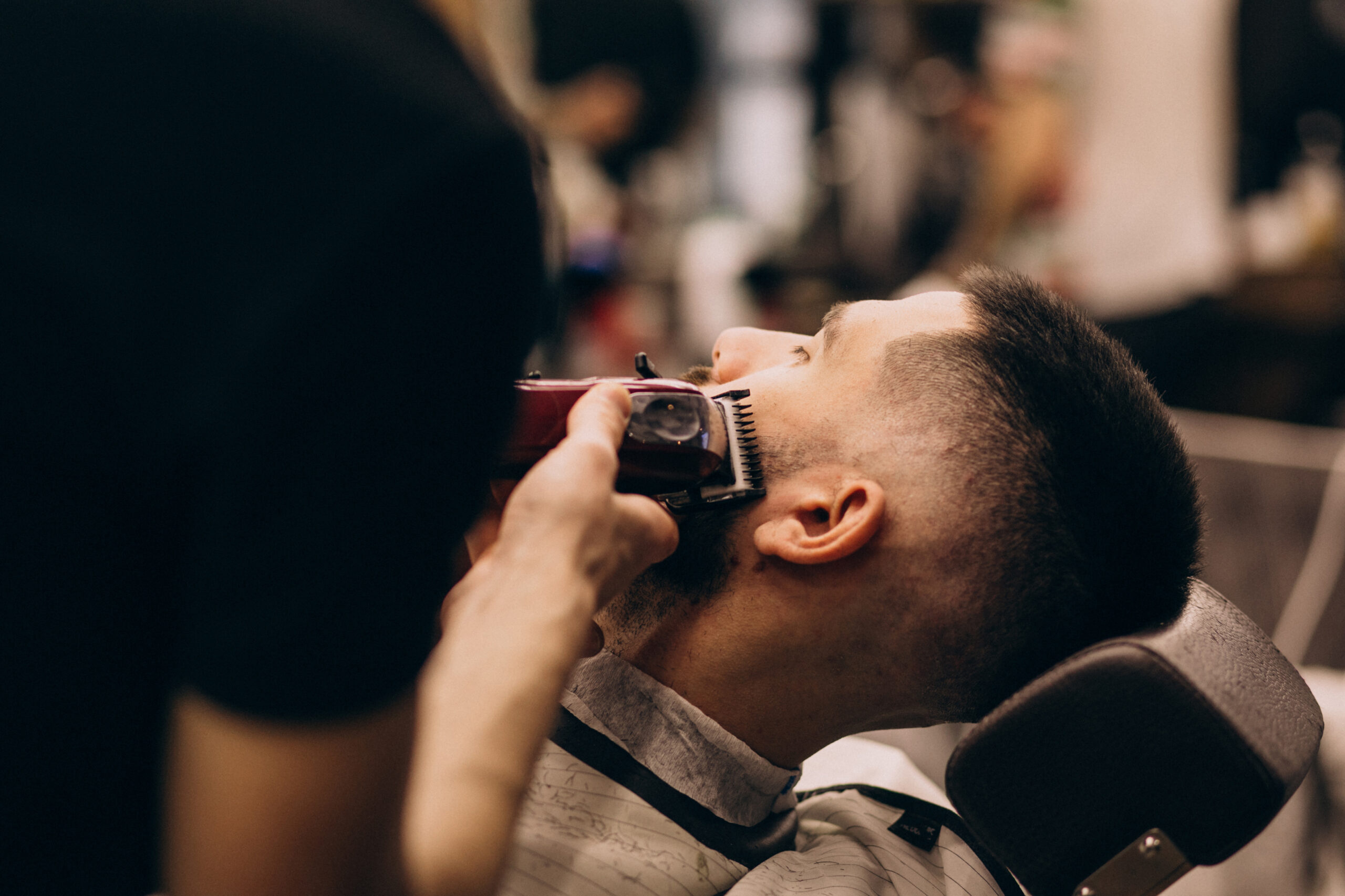 Man at a barbershop salon doing haircut and beard trim